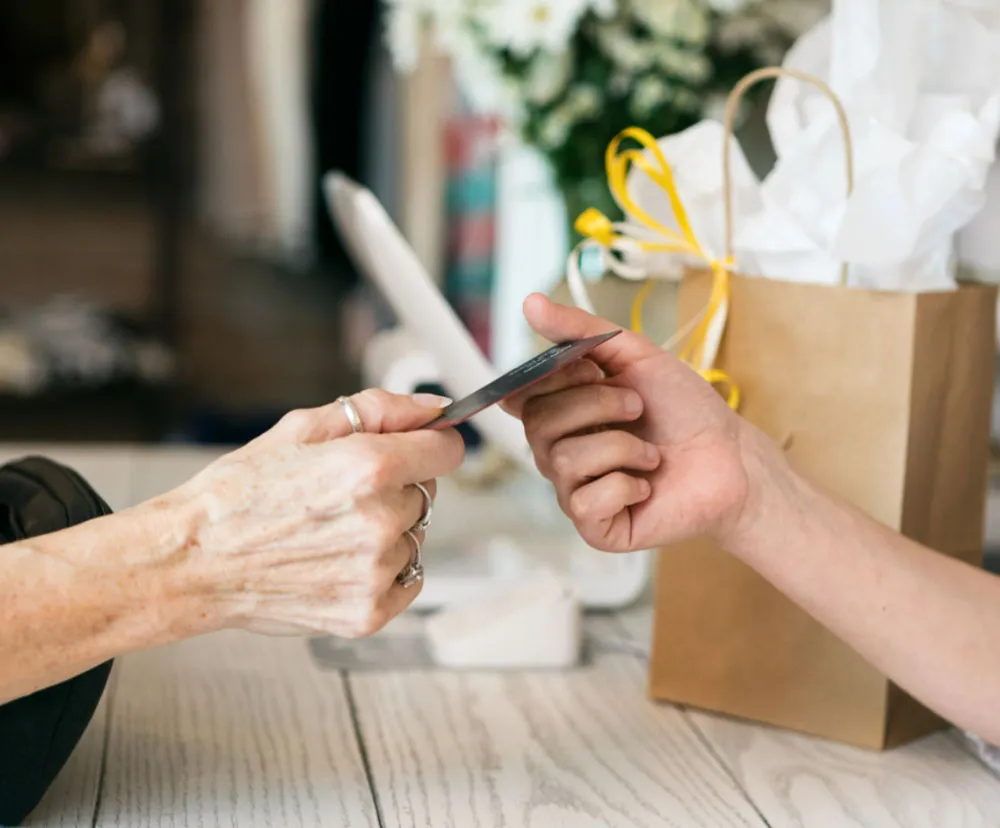 One person handing a payment card to another person