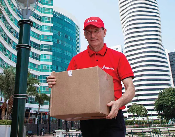 An Urbano Envions delivery man holding a package in downtown background