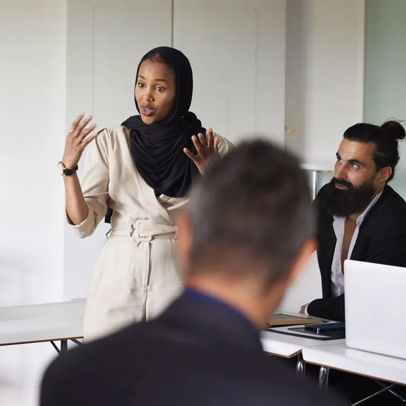 Uma mulher fazendo uma apresentação para seus colegas de trabalho em um escritório