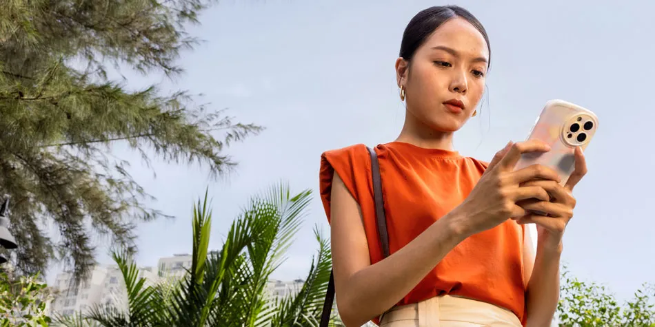 Una mujer al aire libre mirando su teléfono con atención